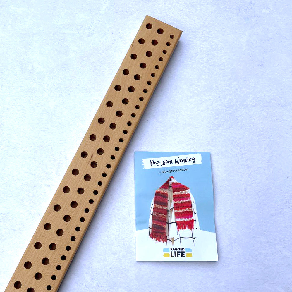 Ragged Life handmade wooden peg loom with three rows of holes and instruction booklet on how to peg loom weave for beginners.