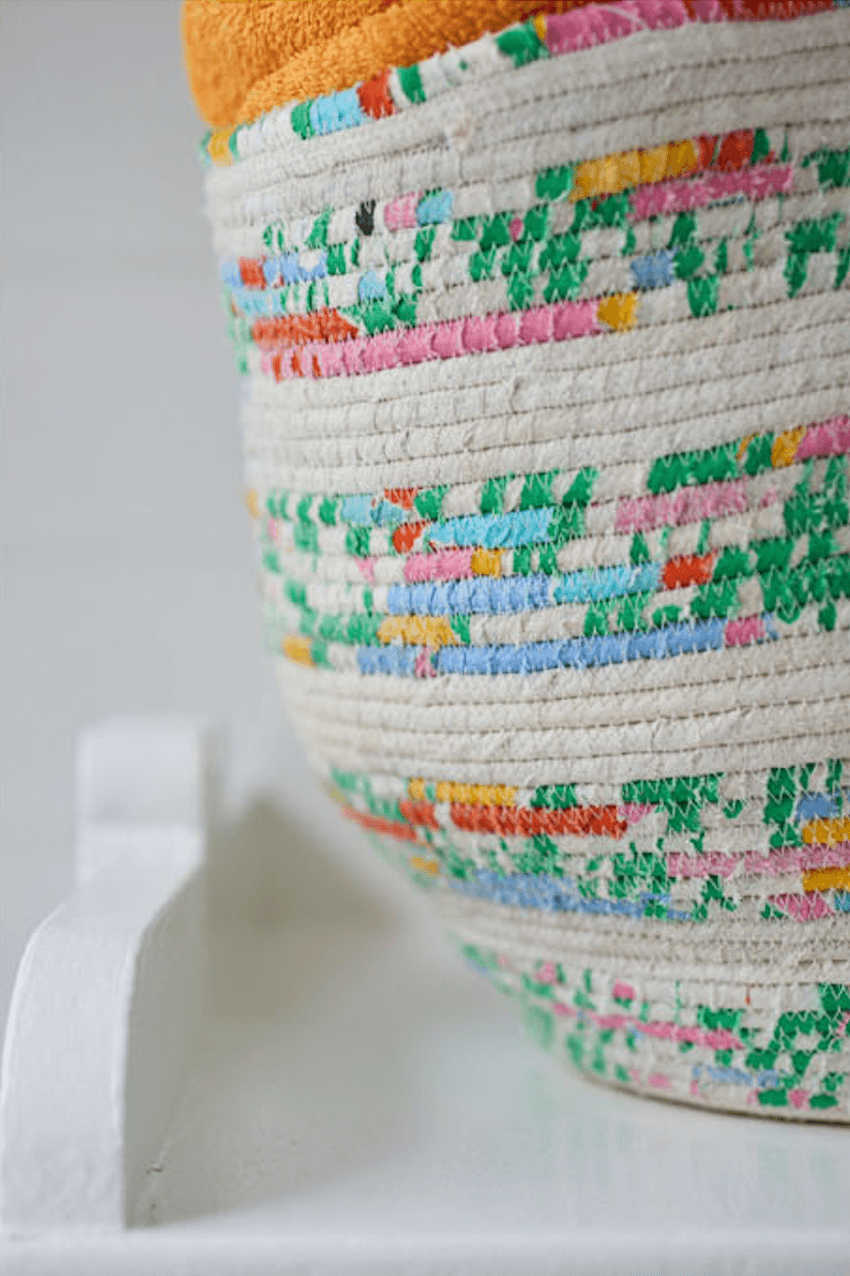 Close up showing zig zag stitch on coiled rope basket made using fabric scraps and old curtains
