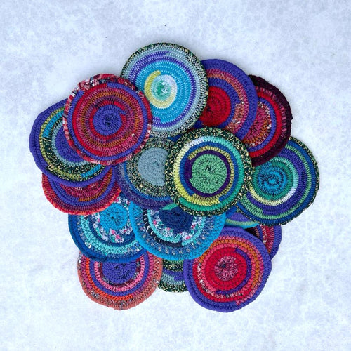 Colorful coiled rope coasters on a white background