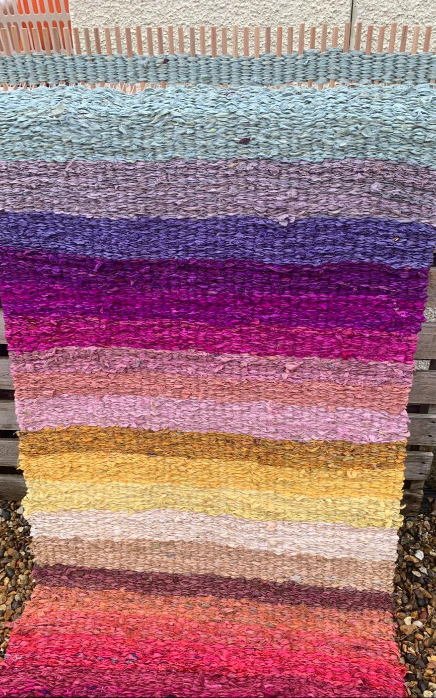 Colourful rainbow peg loom woven rag rug made using recycled sari silk ribbons on a 90cm ragged life peg loom