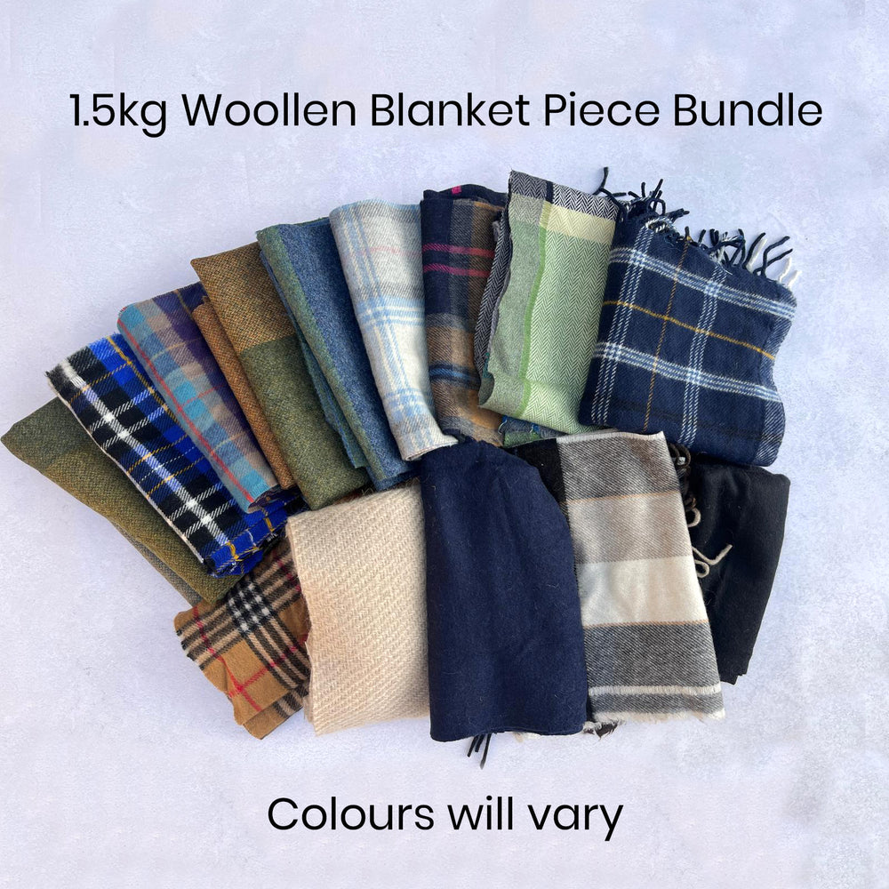 Collection of woollen blanket pieces folded for sewing and patchwork in various colors and patterns, including tartan.