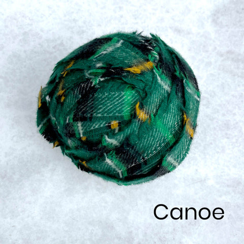 A selection of green Wool Blanket Selvedge Edges balled up for rag rug making - Ragged Life Blanket Yarn