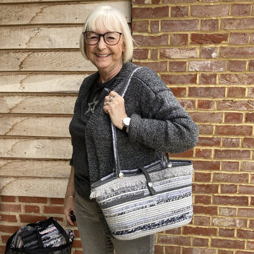 Woman holding a grey coiled rope handmade handbag with handles
