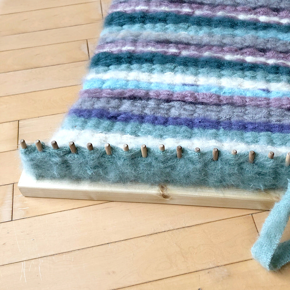 Blue and purple weaving on a Ragged Life 50cm wooden peg loom, perfect for crafting vibrant handmade rugs and textiles