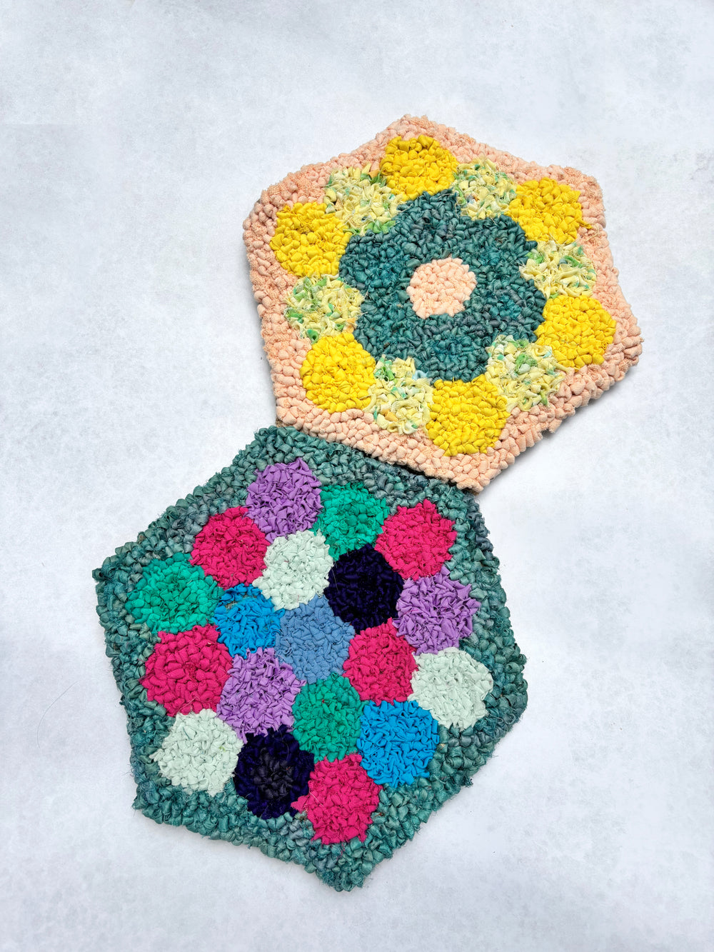 Rug hooked patchwork pieces joined together into community rug 