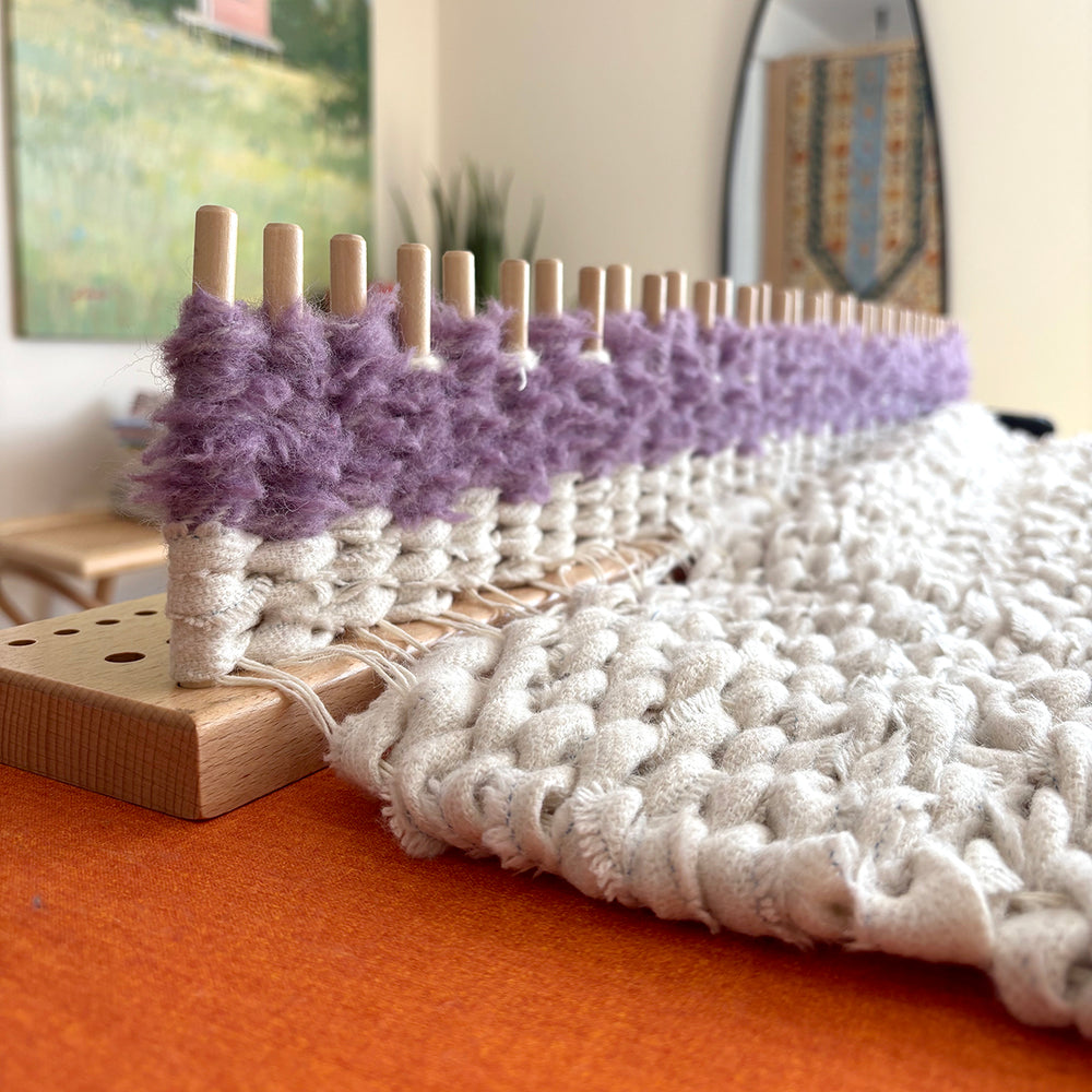 Close up of weaving building up the pegs then down the warp when making a peg loom woven rag rug.