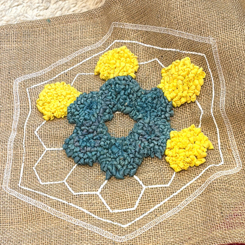 Partially rug hooked hexagon patchwork design in yellow and blue colours