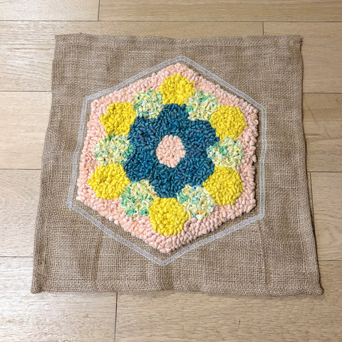 Hexagonal rag rug with a floral pattern on a wooden floor