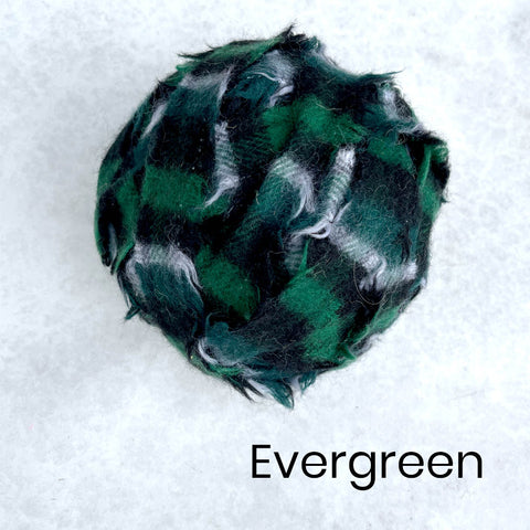 A selection of green Wool Blanket Selvedge Edges balled up for rag rug making - Ragged Life Blanket Yarn